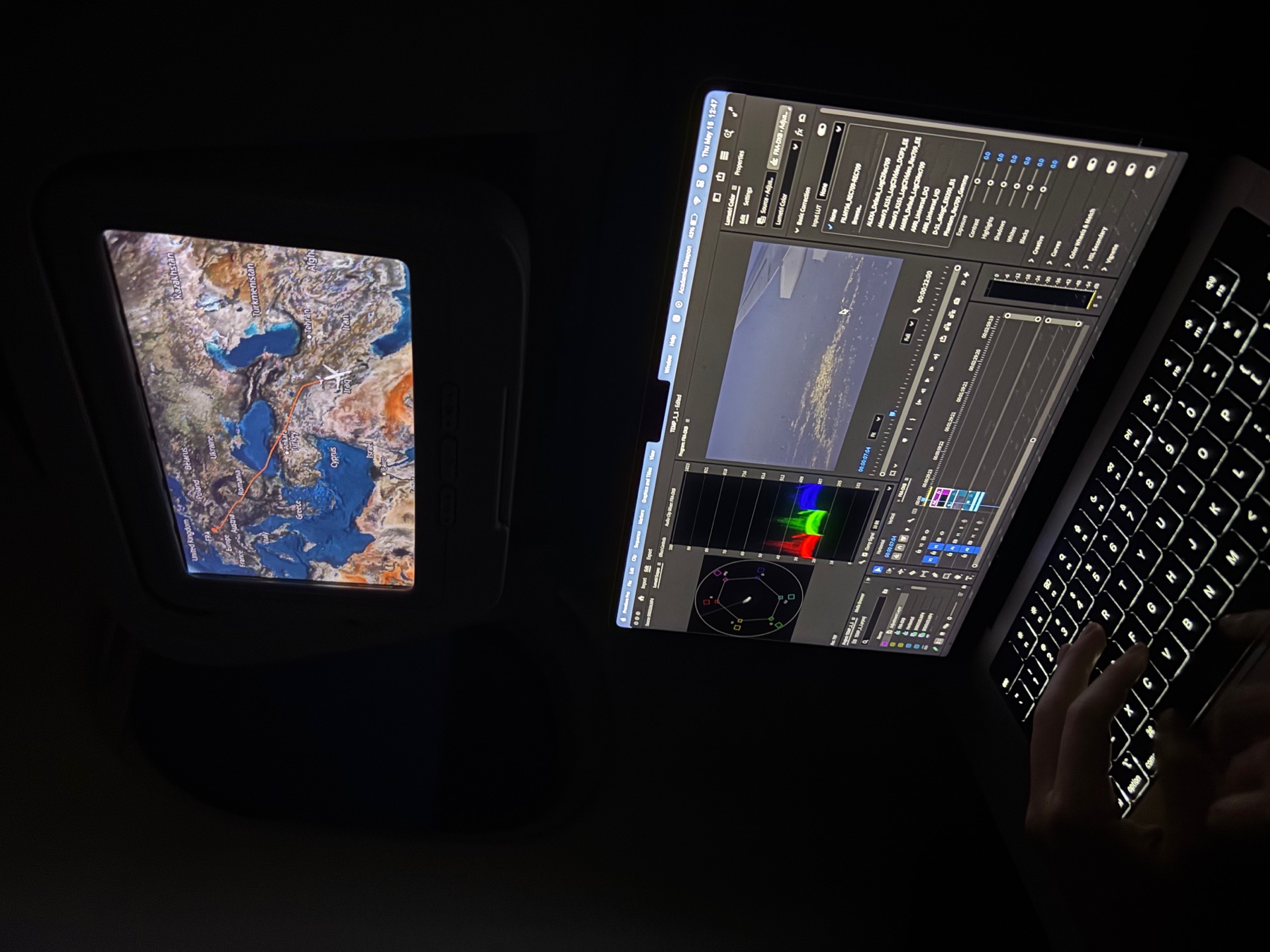 Mobile editing workflow on a laptop during travel with timeline, scopes, and color controls visible.