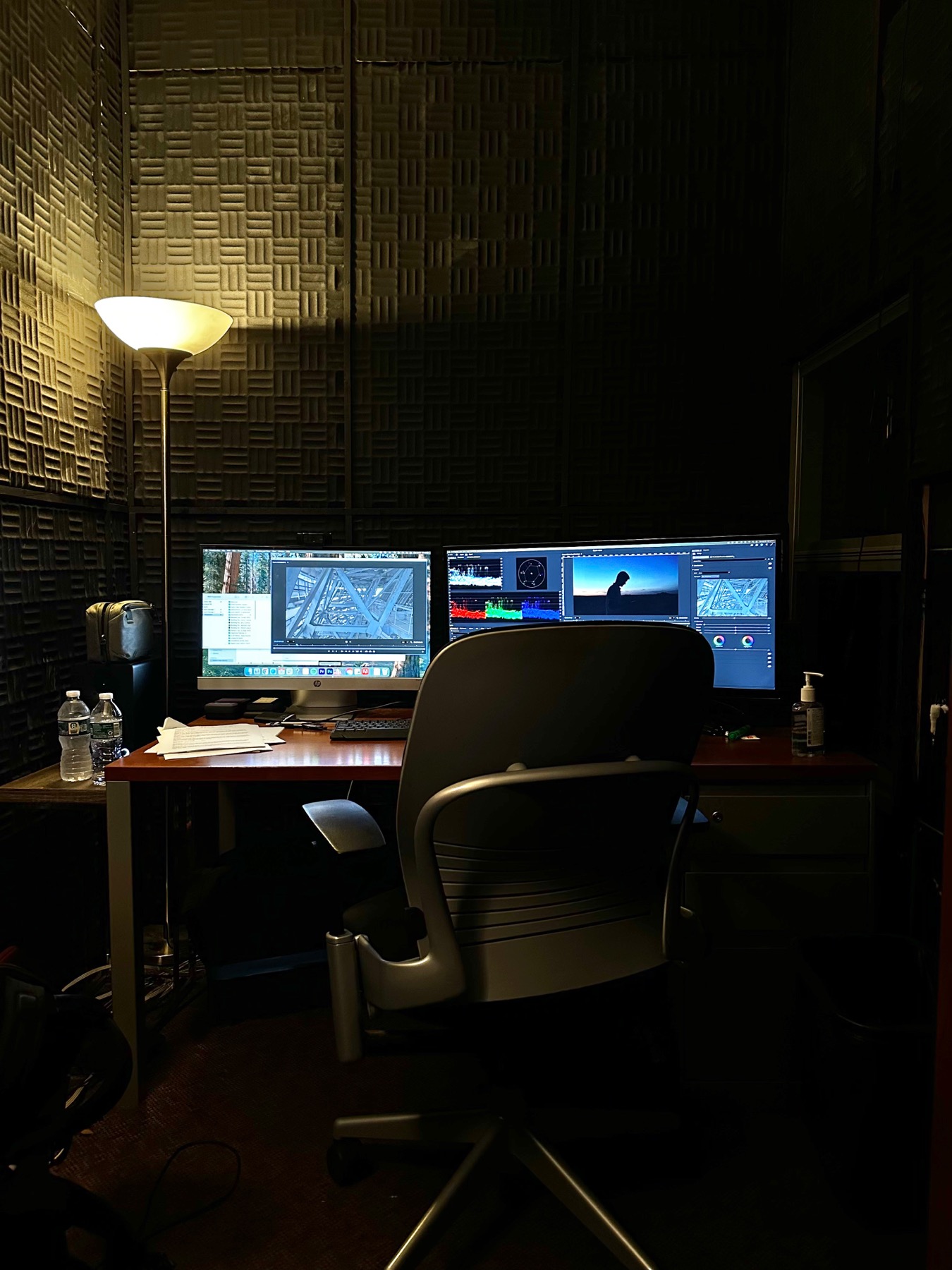 Post-production suite with editing monitors, scopes, acoustic panels, and desk setup.